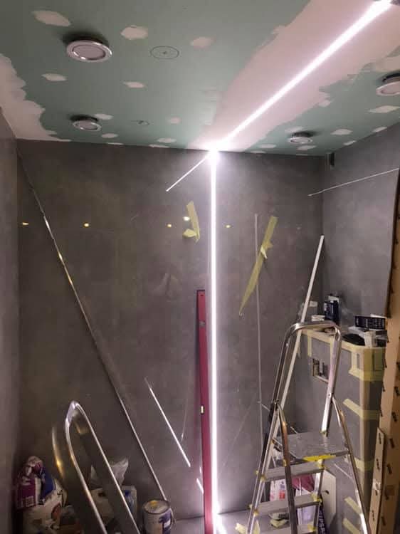 Bagno con grandi lastre e fughe LED a Toruń
